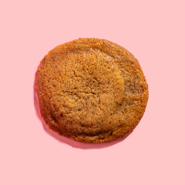 A golden Dohful cookie on a pink backdrop
